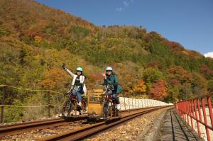 Image of two people running on mountain bike with peace sign